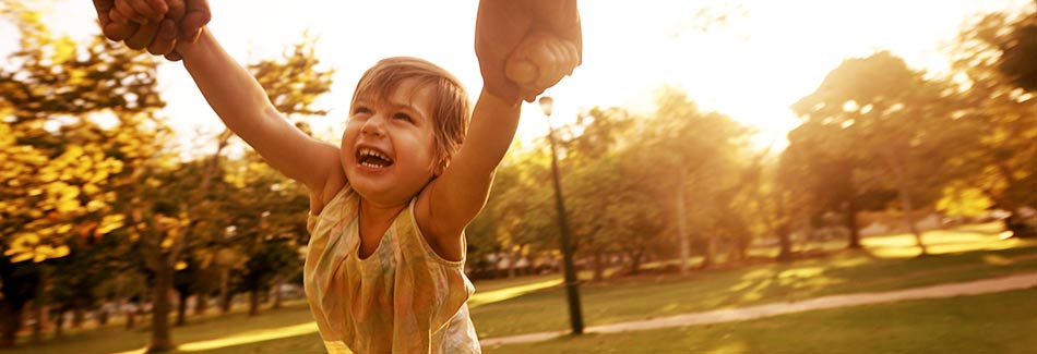 Daughter swinging from dad's arms