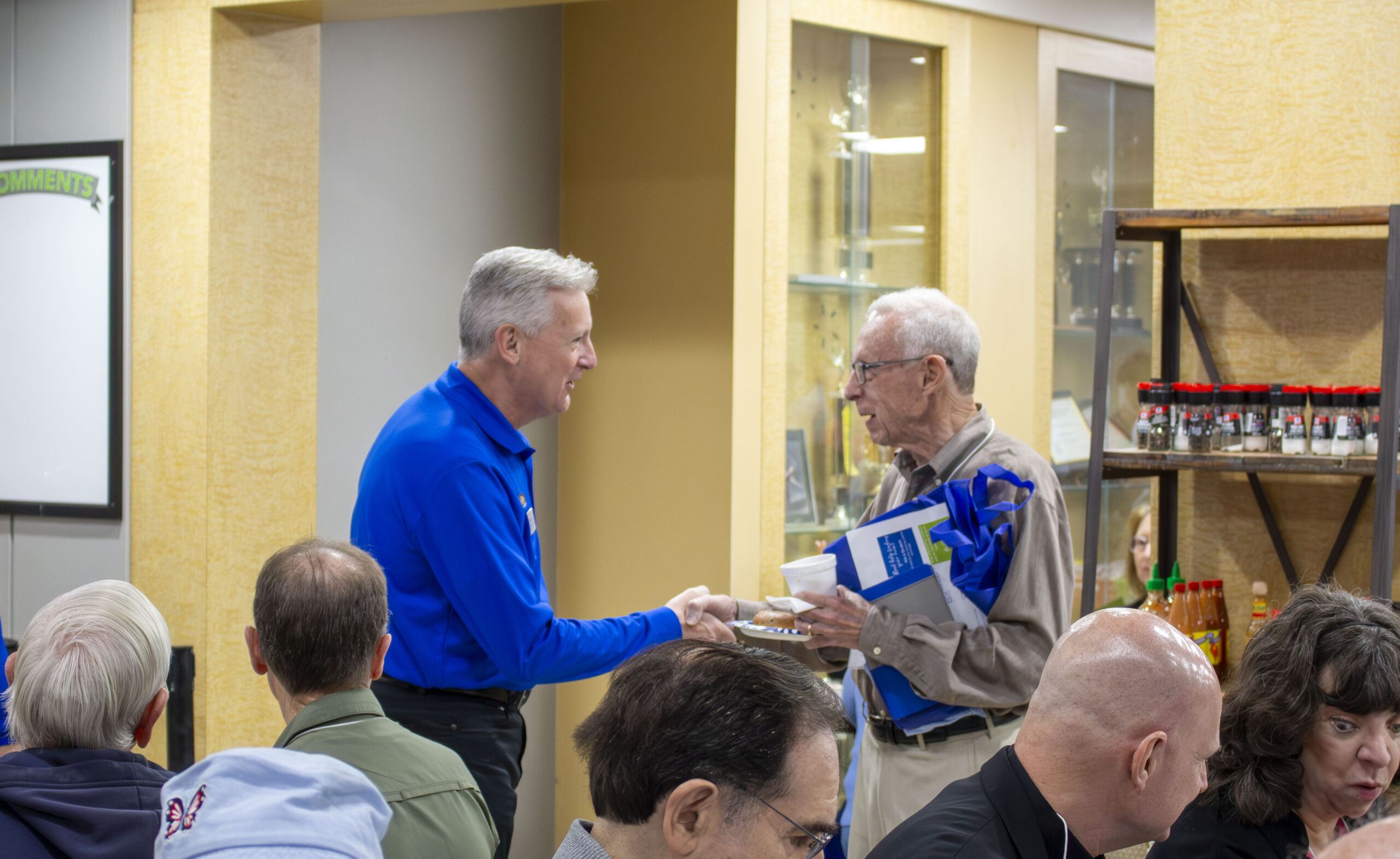 Executive Director Mike Mies shaking hands with event attendee